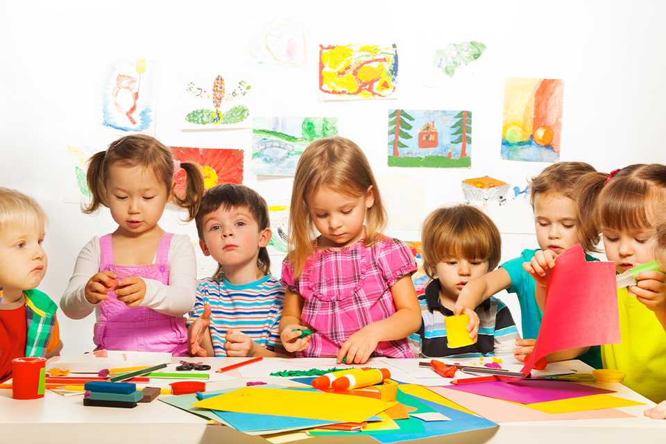 Kids making card crafts with colourful papers.