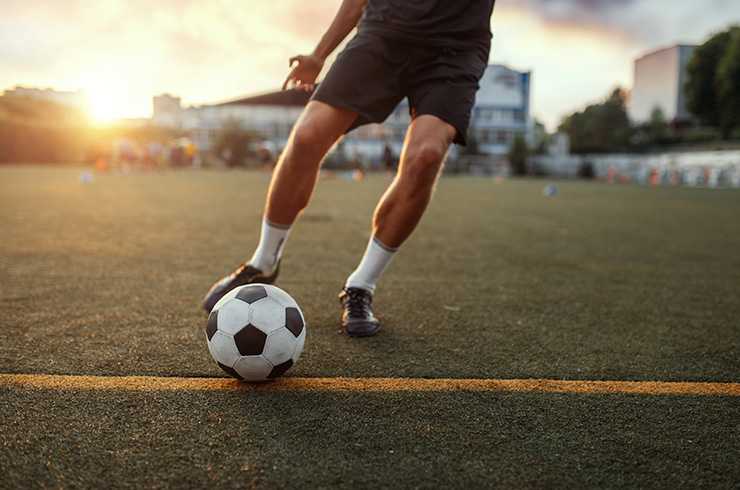 close up of a footballer and football