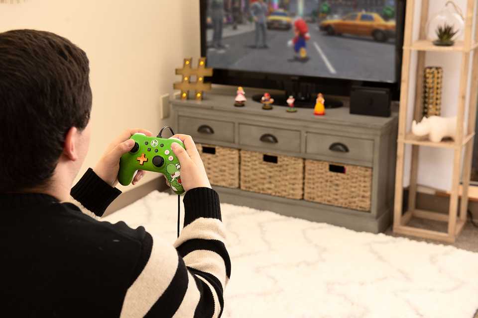 A kid playing a game with a PowerA Licensed Nintendo Switch Wired Controller.