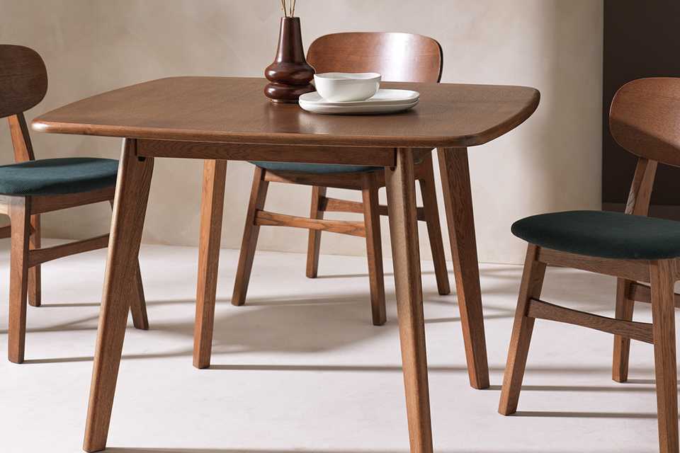 A Habitat x Scion Esala wood veneer four-seater dining table and three chairs in a dining room.