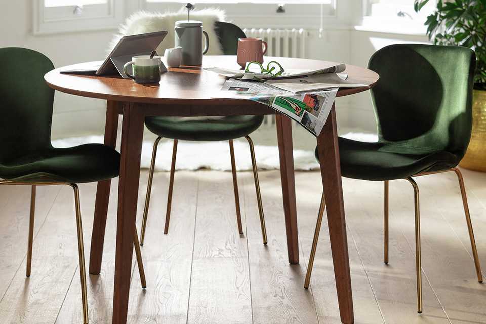 A Habitat Skandi Walnut Veneer Round 4 Seater Table with chairs in a dining room.