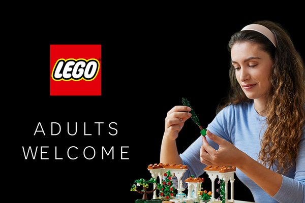 A woman playing with the LEGO® Icons Fountain Garden set against a black background.