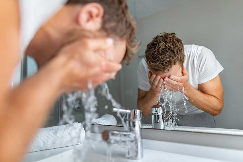 A man splashing water on his face.