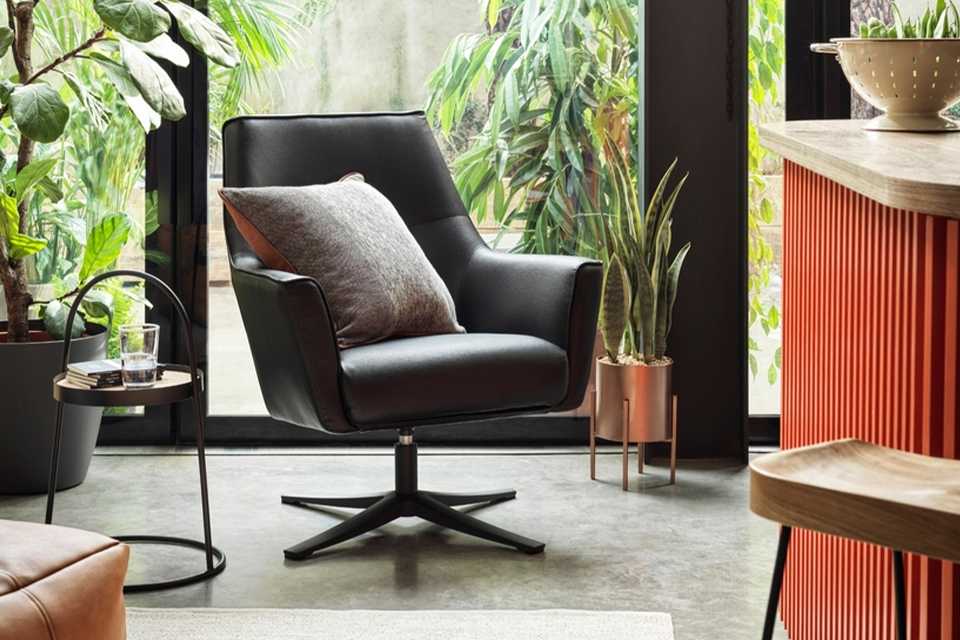 Image of a black swivel chair with grey cushion in a conservatory.