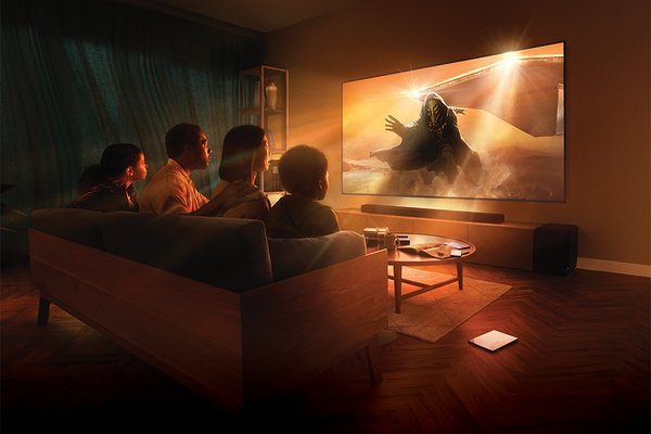 A family of four watching an illuminated Sony televisison screen.