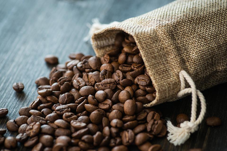 Coffee beans being tipped out of a fabric bag.