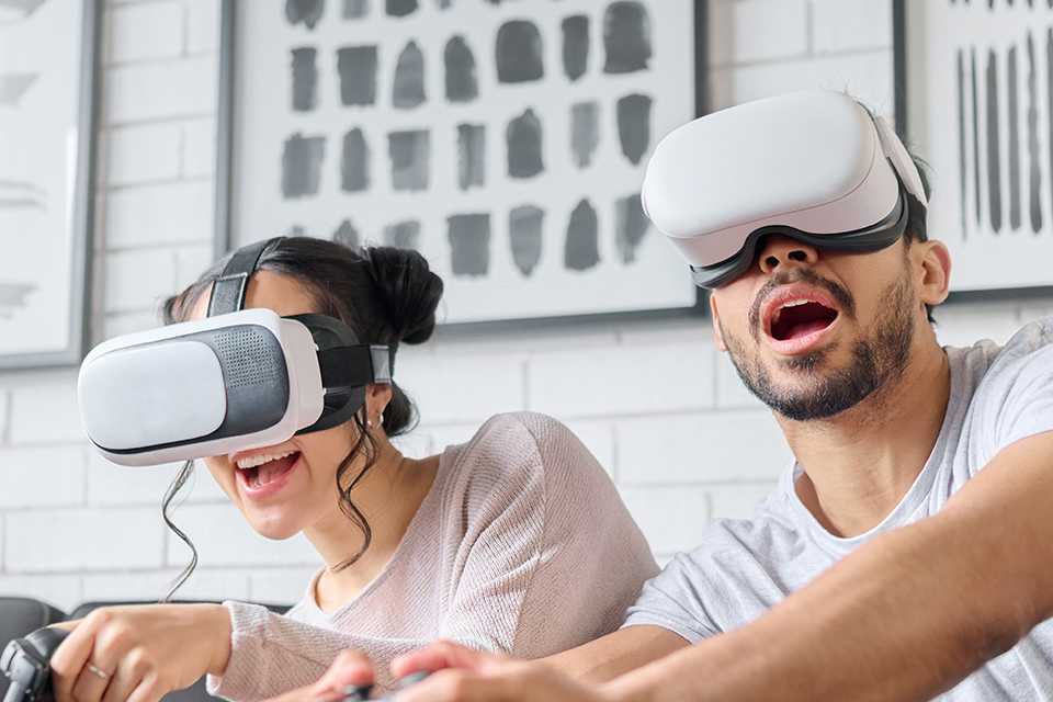 A man and a woman playing a game using VR headsets.