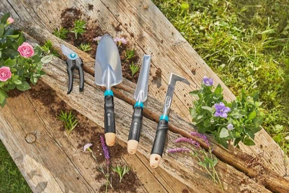 Gardena EcoLine Hand Tools and Secateurs placed on a plank with flower plants.
