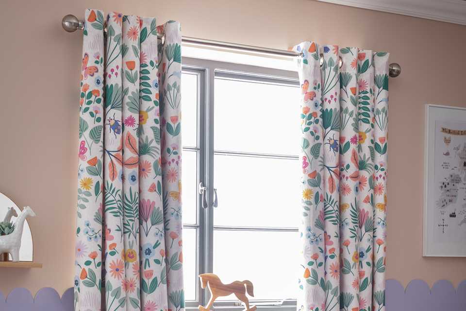 A Habitat Kids floral blackout eyelet curtain on a curtain pole.