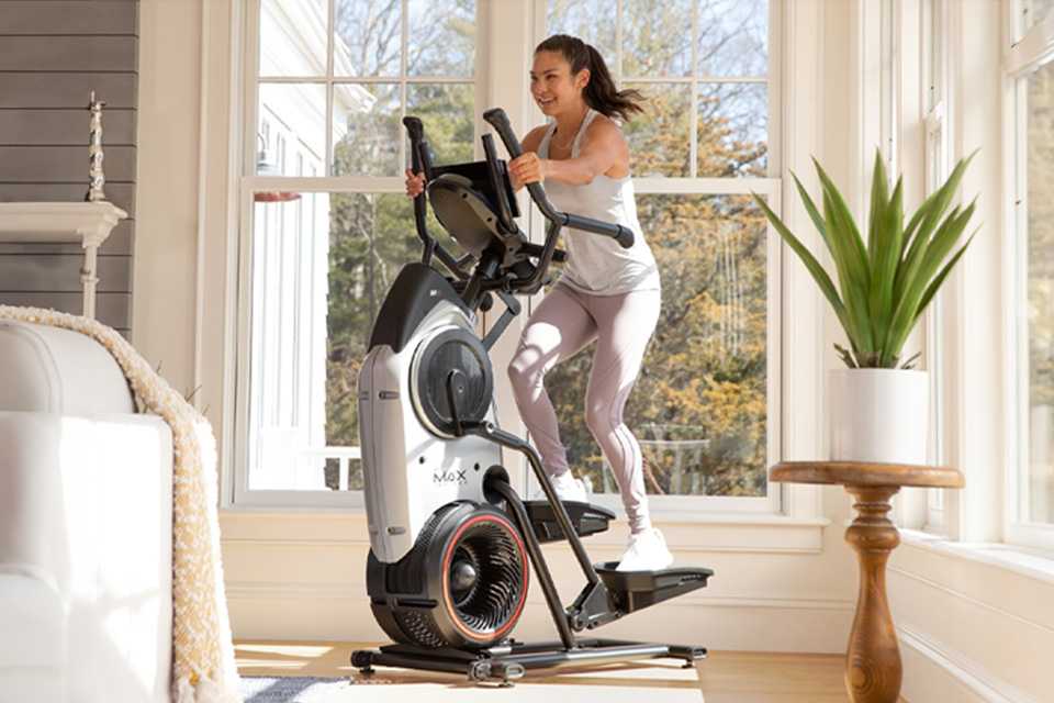 A woman using BowFlex M6 Max Trainer at her home.