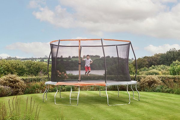 Large trampoline in a garden with a child playing