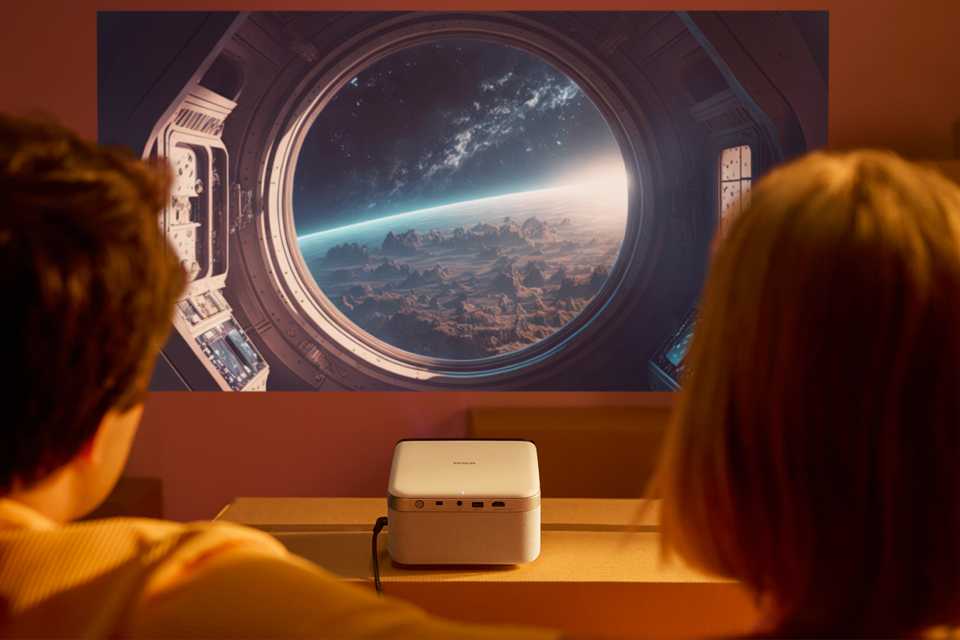 Couple watching a space movie projected on the wall.