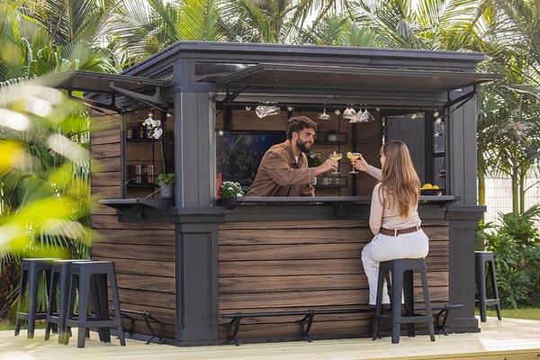 A couple enjoying cocktails together at a Keter Rosewood Bar Shed.