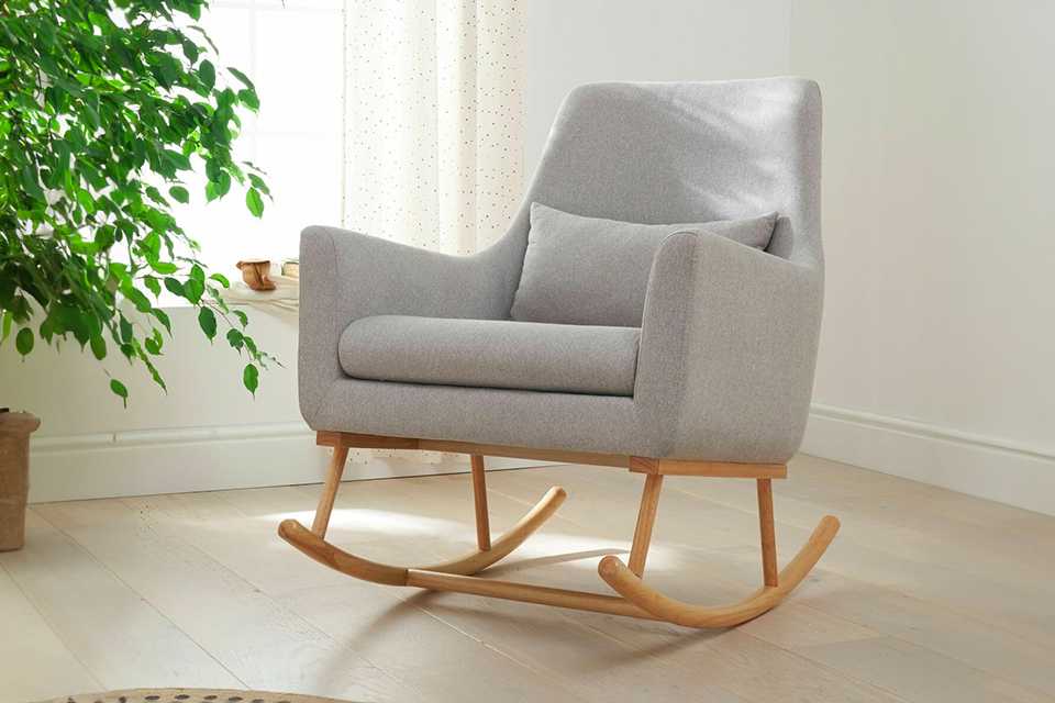 A Tutti Bambini Oscar rocking nursing chair in a room near an indoor plant.