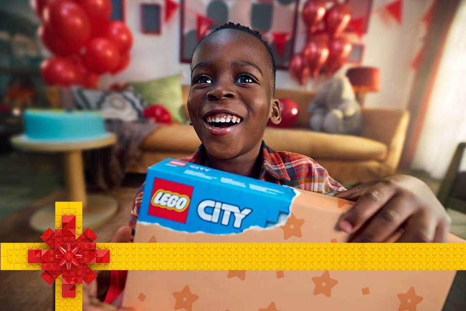 Little boy holding a LEGO® City present.