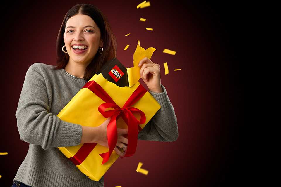 Woman opening a LEGO® gift.