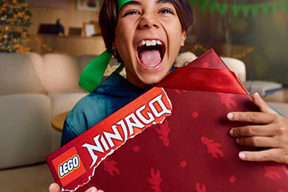 Boy opening a LEGO® NINJAGO gift.