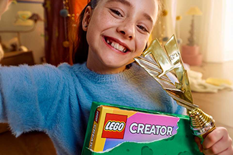 Girl opening a LEGO® Creator gift.