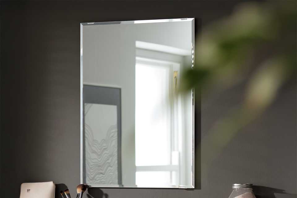 A rechtangular mirror in a bathroom.