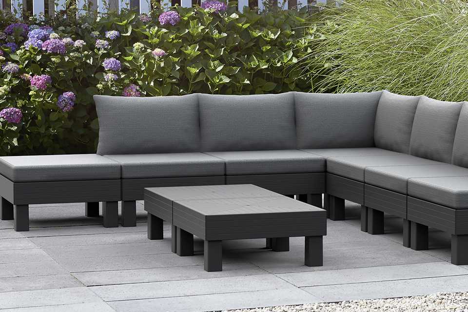A grey Keter Elements 7 seater modular resin lounge set placed outdoors.