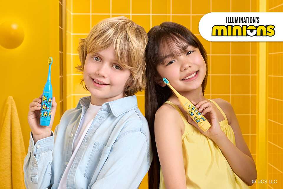 Boy and girl holding their Minions ORDO Sonic Kids Toothbrushes in blue and yellow colours.