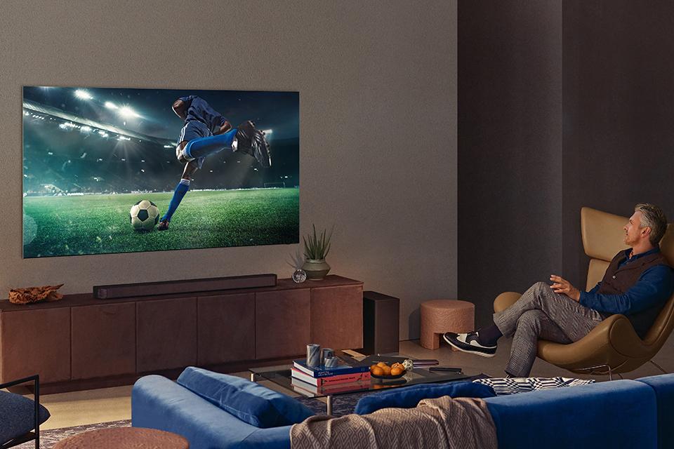 Man watching football on the TV in the lounge.