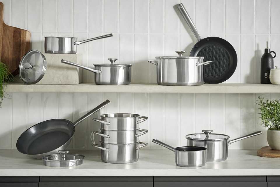 A collection of Habitat 20cm Brushed Stainless cookware displayed on a kitchen counter.