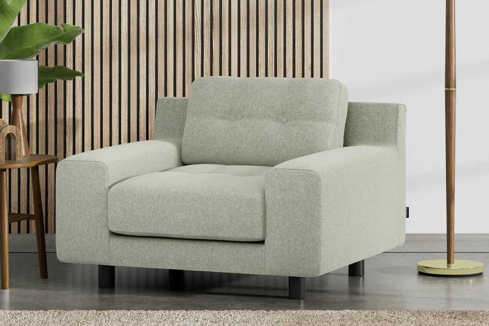 A Habitat Hendricks Fabric arm chair in sage green with black legs.