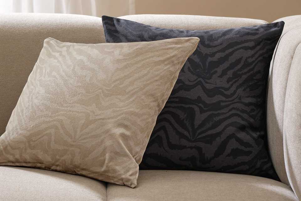 Two cushions with Habitat 2 pack Zebra print cushion covers on a white sofa.