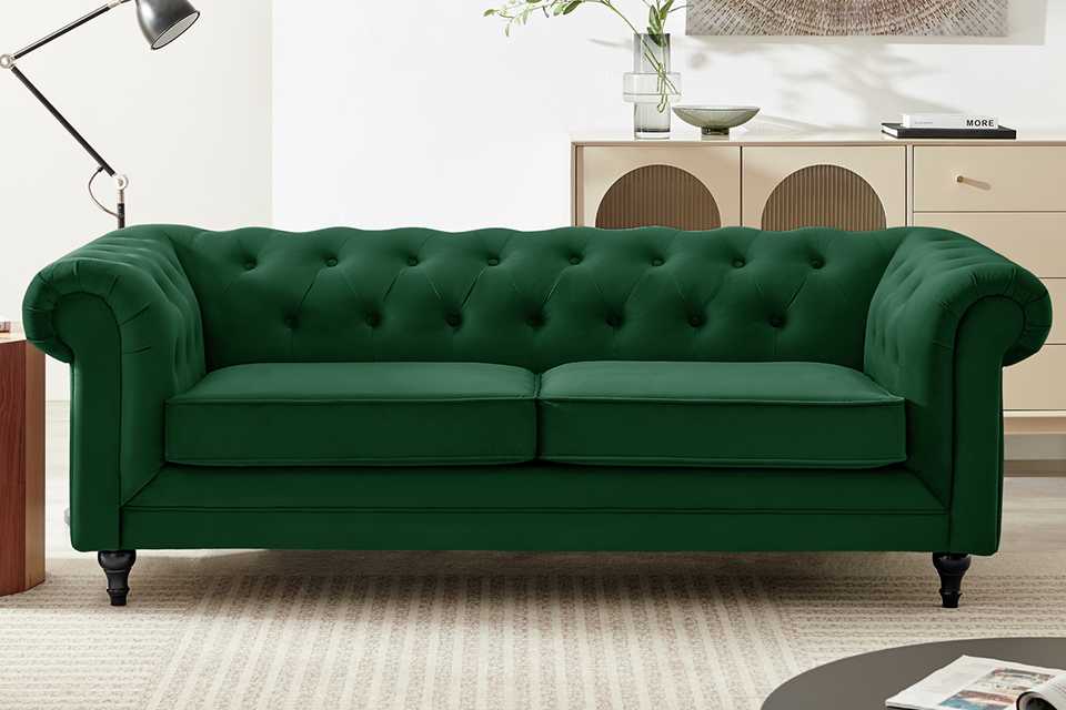 A green, velvet sofa in a living room.