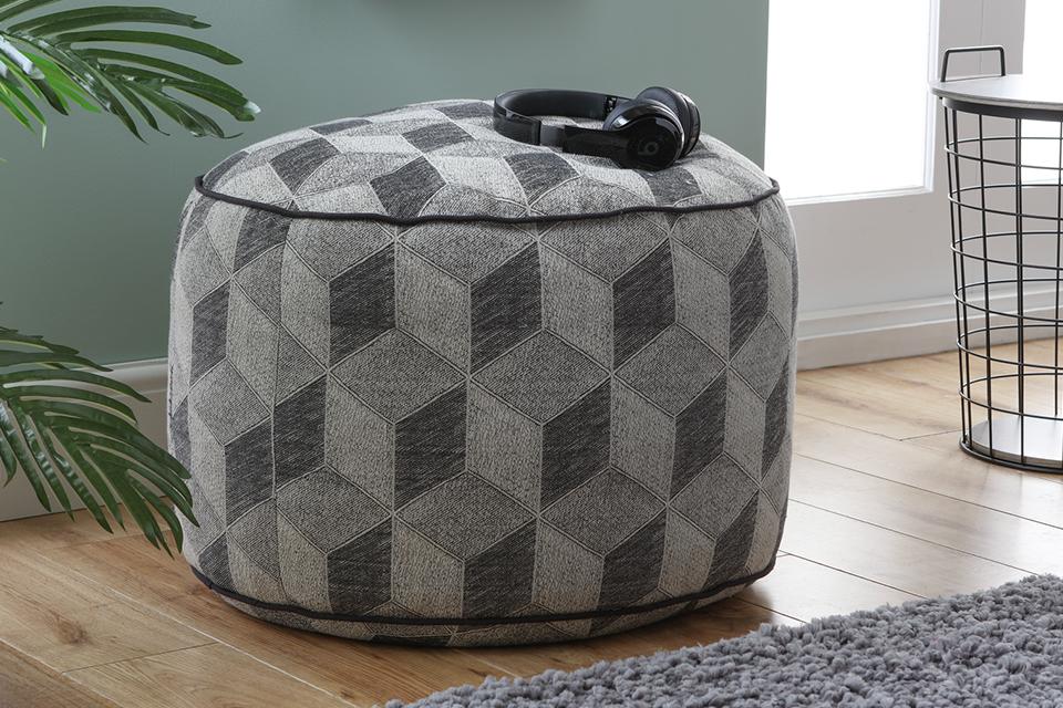 A geometric patterned footstool in a living space.