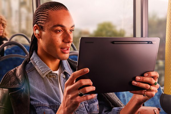 A man on train looking at a tablet.