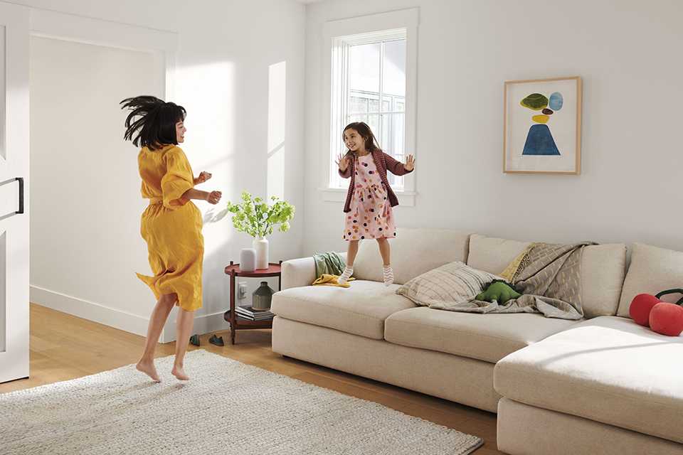 A family dancing to music from a Google Nest smart speaker in their living room.