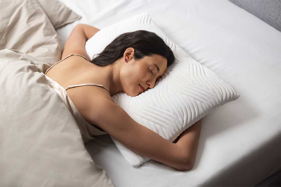 A woman sleeping on a TEMPUR® classic pillow.