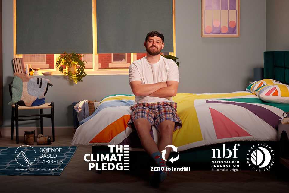 A man sitting on a SIlentnight bedding with various sustainbilty logos present in white at the bottom of image.