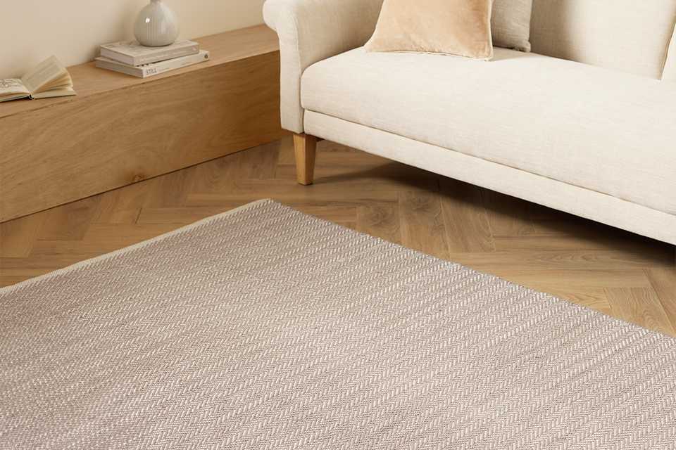 An Argos Home herringbone grey cotton flatweave rug in a living room.