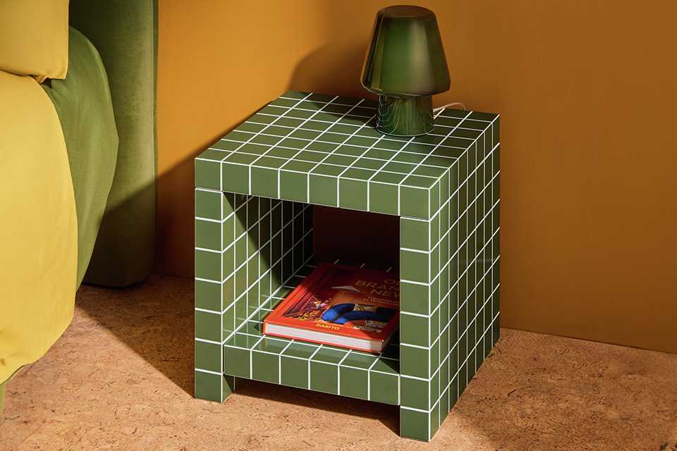 A green Habitat table lamp placed on a bedside table.