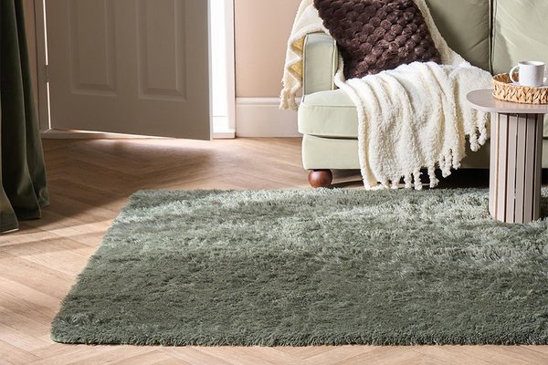 An OHS soft green fluffy fleece rug in a living room next to a sofa.