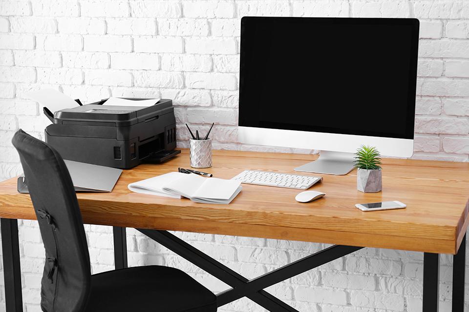 Workplace with computer monitor on table in office.