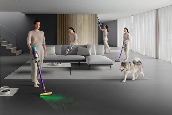 A woman showing different functionalities of the pet-friendly Dyson Gen 5 detect cordless vacuum cleaner, with laser function.