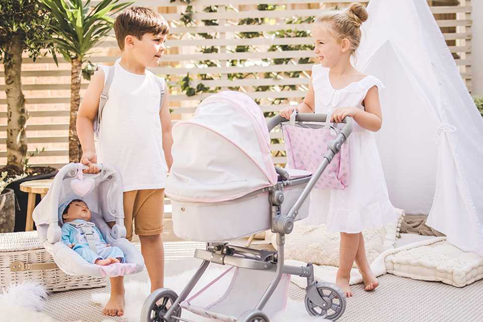 Girl pushing Tiny Treasures baby doll pram and boy holding Tiny Treasure car seat with baby doll.