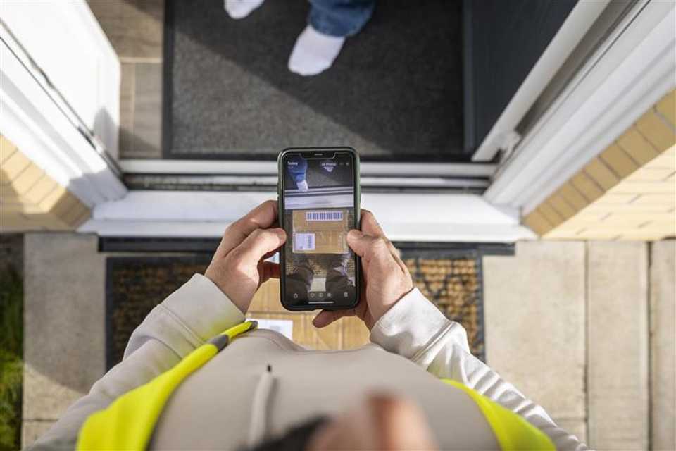 A person collecting a parcel from a delivery man.