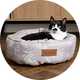 A cat sitting on a small sized Scruffs taupe coloured botanical ring bed.