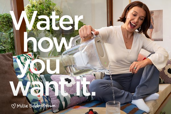 Actress Millie Bobby Brown pouring water from a BRITA Style Essential Water Filter Jug into a glass.