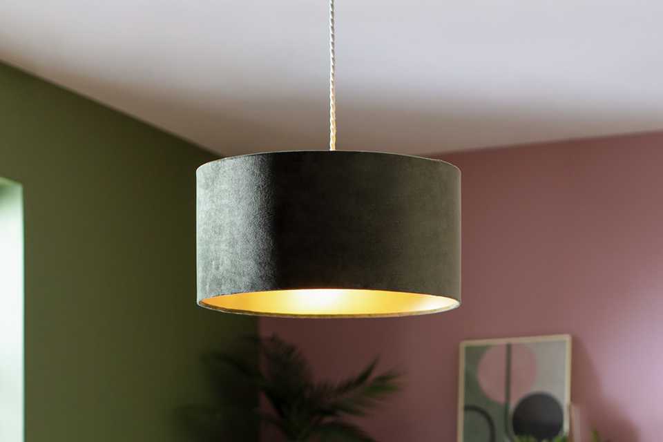 A Habitat Home green velvet lampshade in a bedroom.