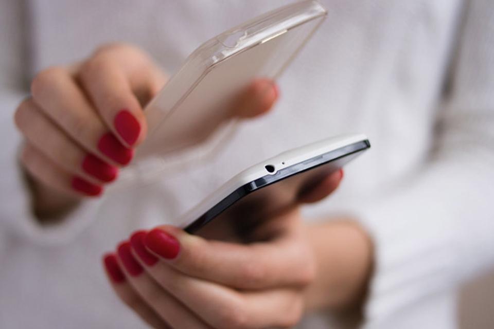 Woman puts a new case on a mobile phone.