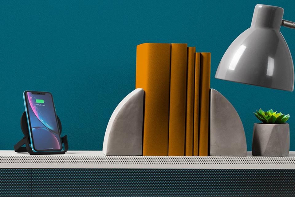 Smartphone charging wirelessly on shelf.