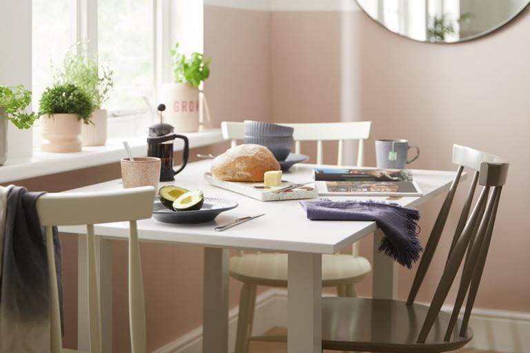 Image of white dining table and 3 chairs next to window.