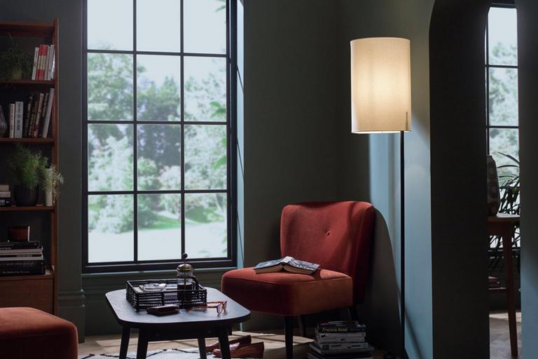 Image of a floor lamp illuminating an armchair and coffee table.