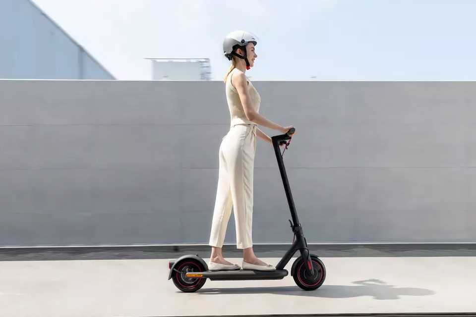 A woman riding a Xiaomi electric scooter.
